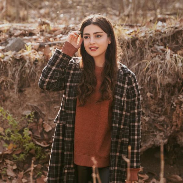 Person stretching gently outdoors with a serene natural background.